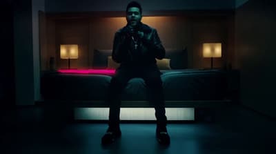a man sitting on a bed in a dark room