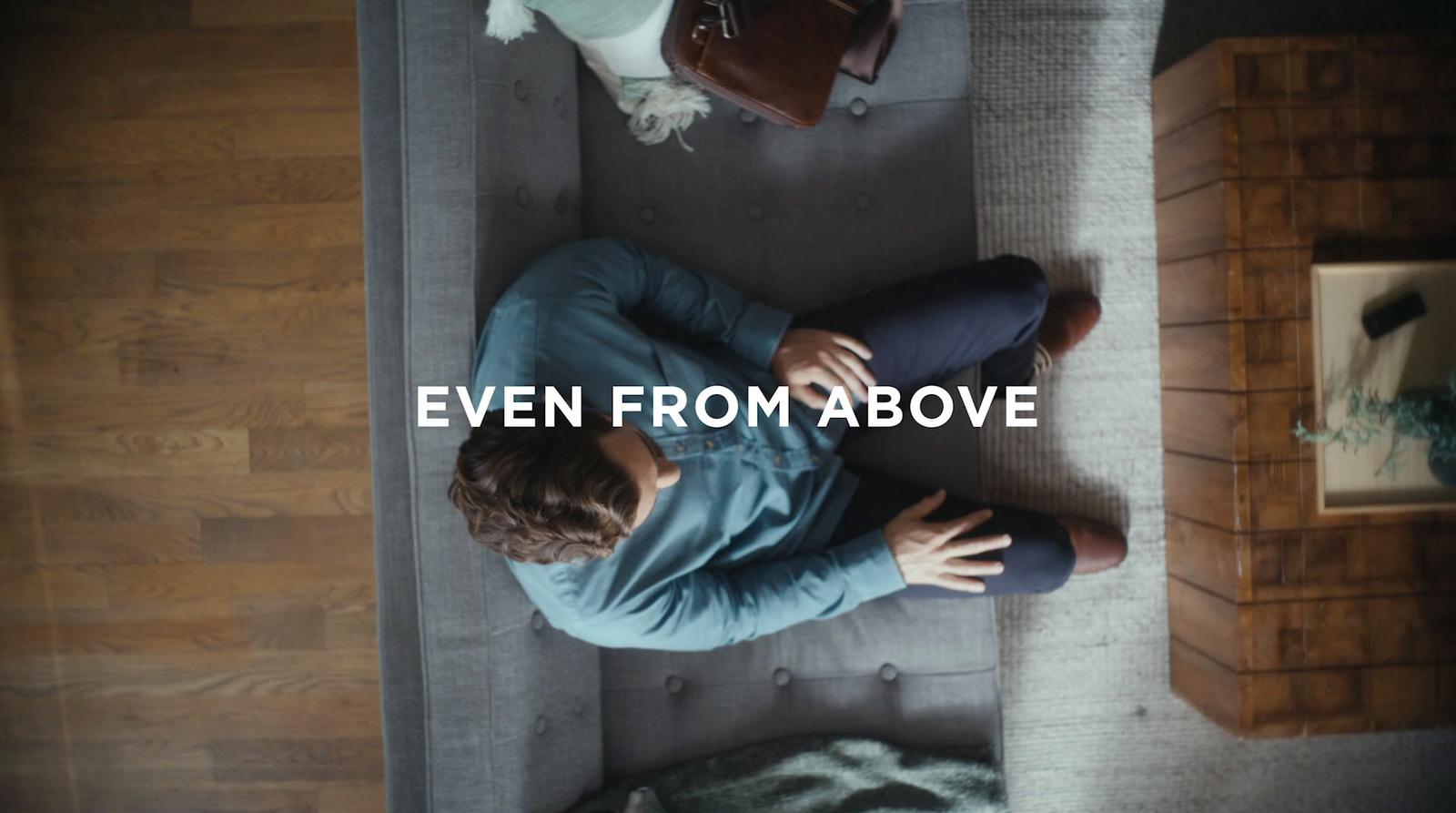 a man sitting on a couch with the words even from above