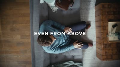 a man sitting on a couch with the words even from above