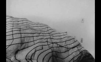 a black and white photo of a blanket on a bed
