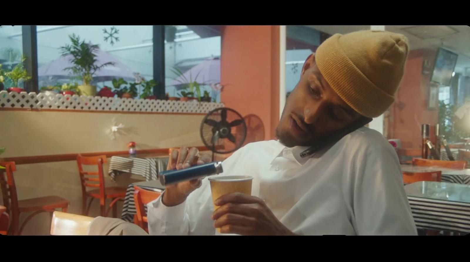 a man sitting at a table with a cup of coffee