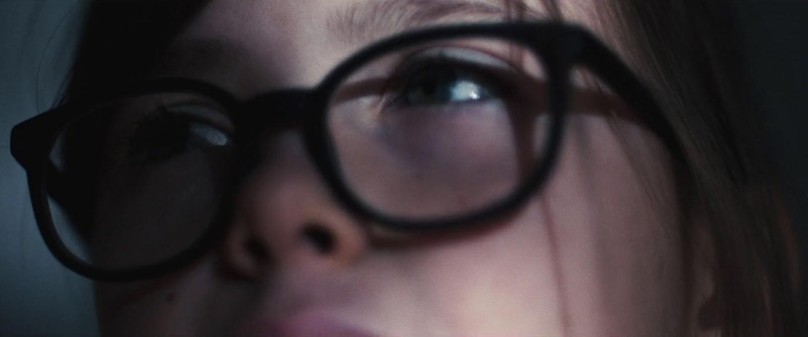 a close up of a woman's face with a pair of glasses on her