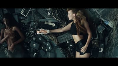 a woman in a bikini standing next to a pile of electronic equipment