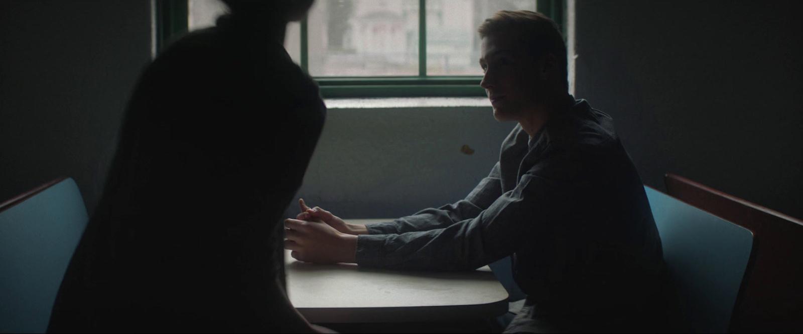 a man sitting at a table in front of a window