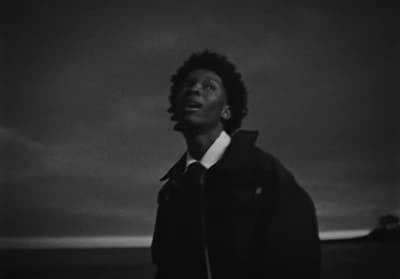 a man standing in front of a cloudy sky