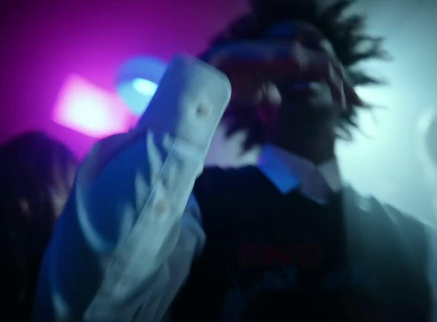 a blurry image of a man holding a remote control