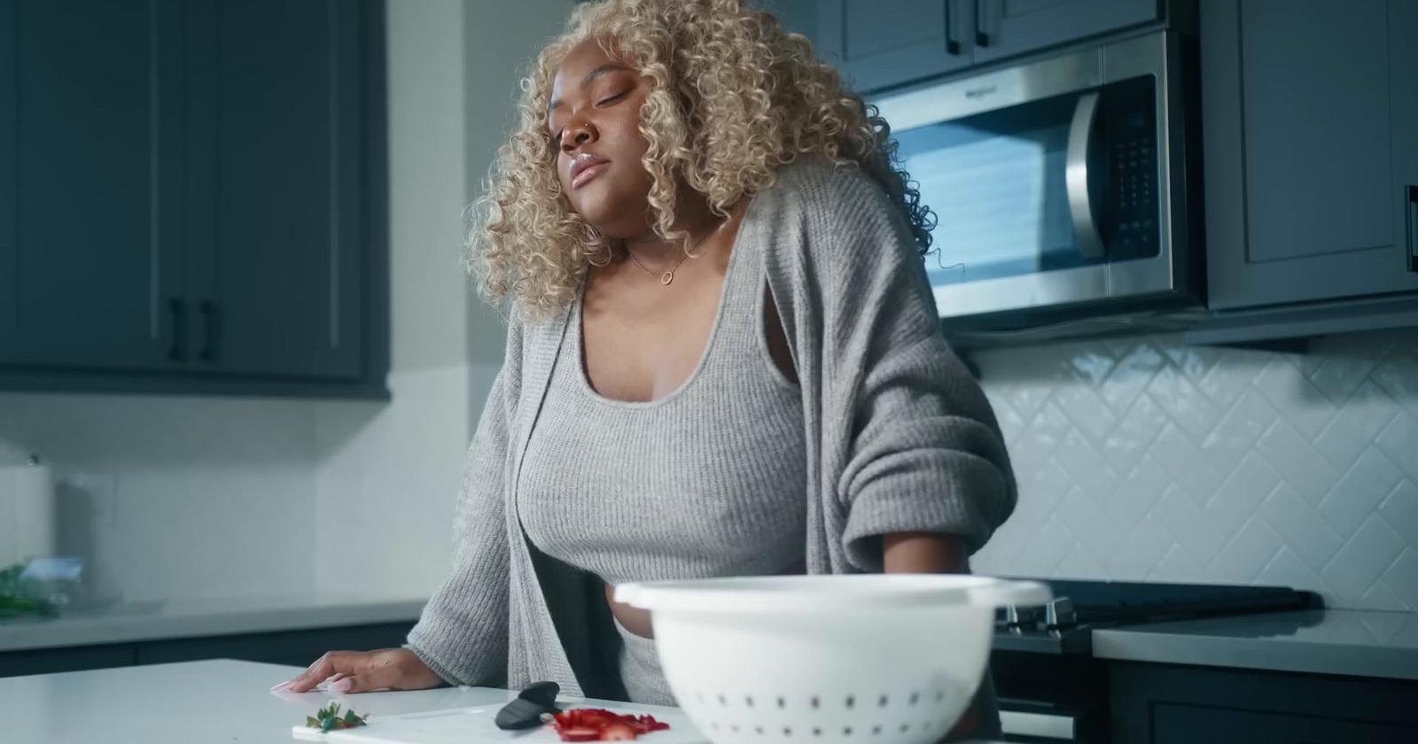 a woman standing in a kitchen preparing food
