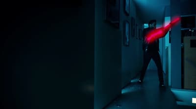 a man standing in a hallway with a red light on his arm
