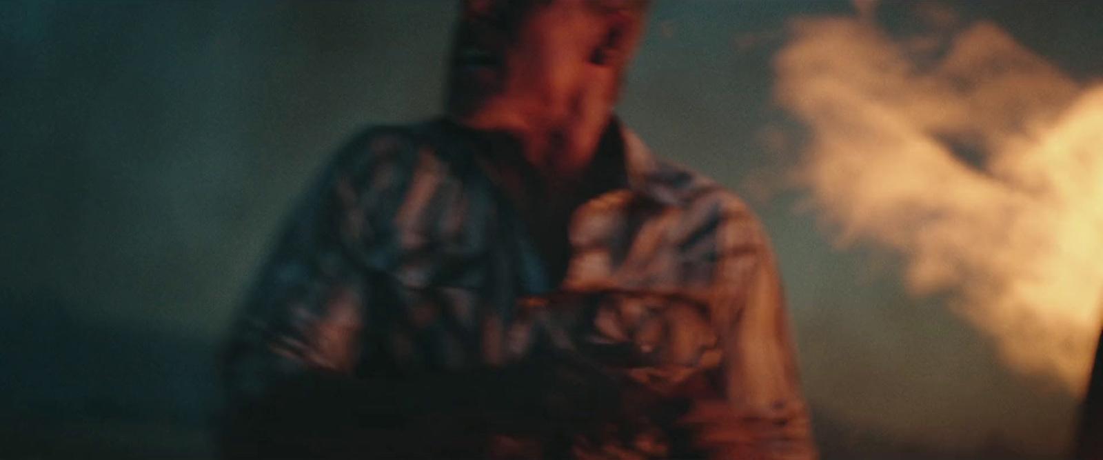 a man standing in front of a fire with smoke coming out of his mouth