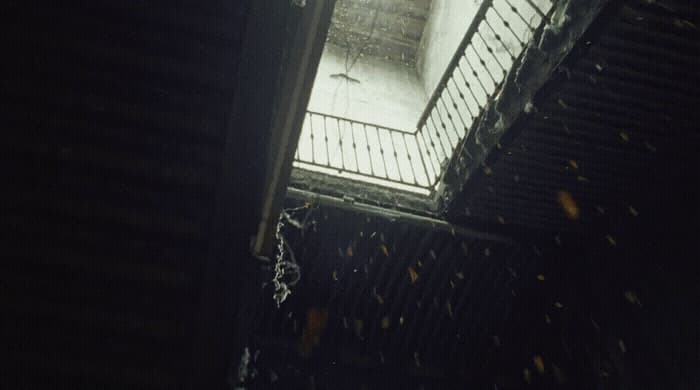 a dark room with a light coming through the window