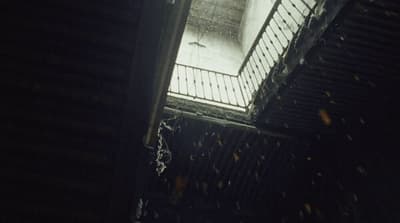 a dark room with a light coming through the window