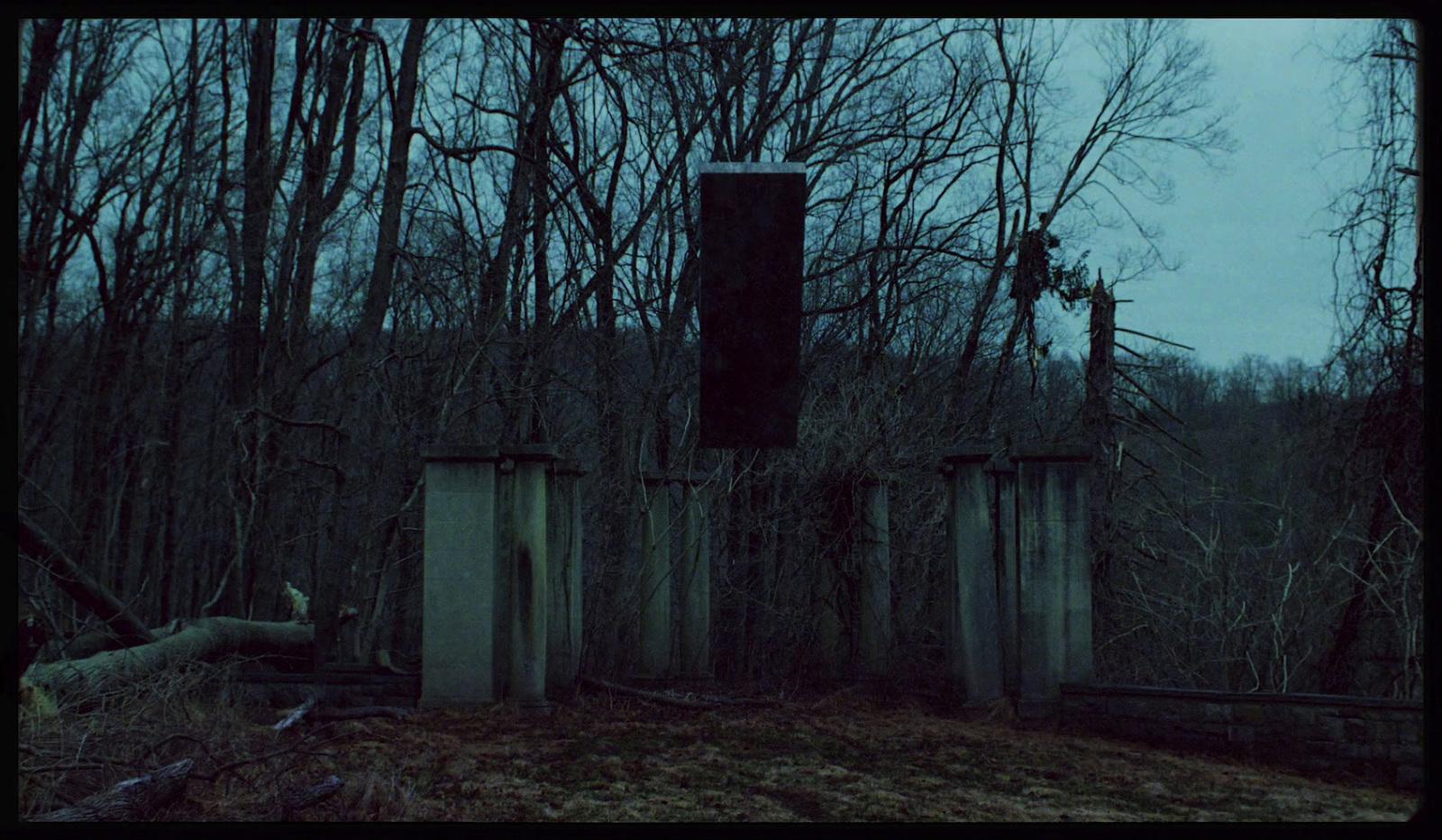 a creepy picture of a gate in the woods