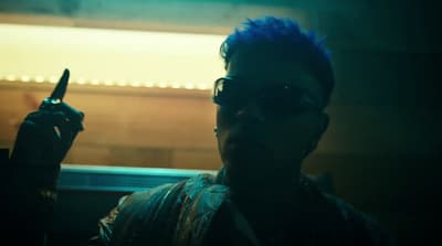 a man with blue hair holding a knife in his hand