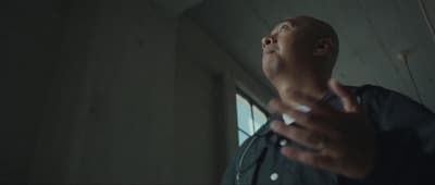 a man standing in a room with a cigarette in his hand