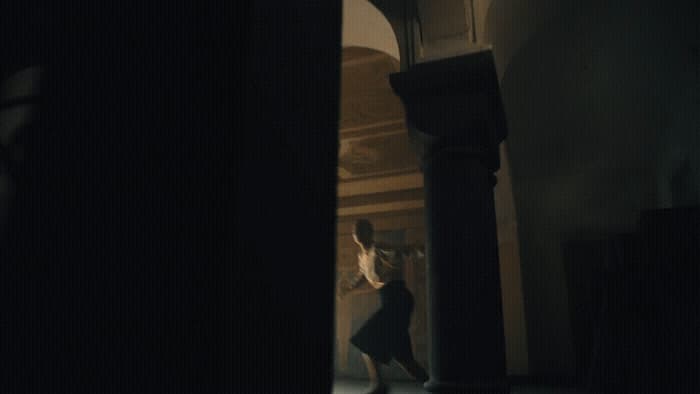 a man is walking through a dark hallway