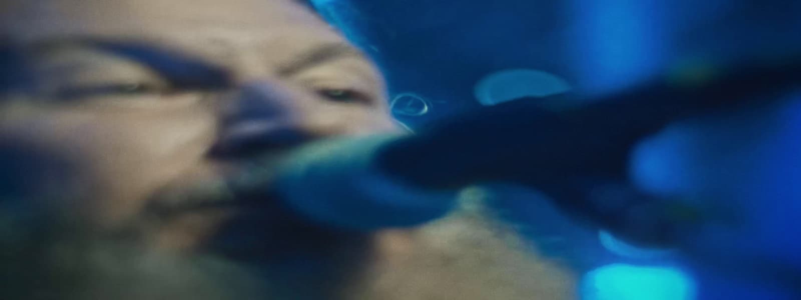 a close up of a person singing into a microphone