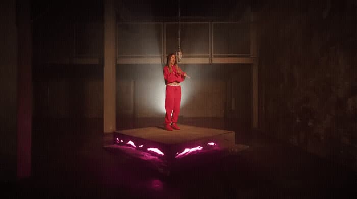 a woman standing on a platform in a dark room
