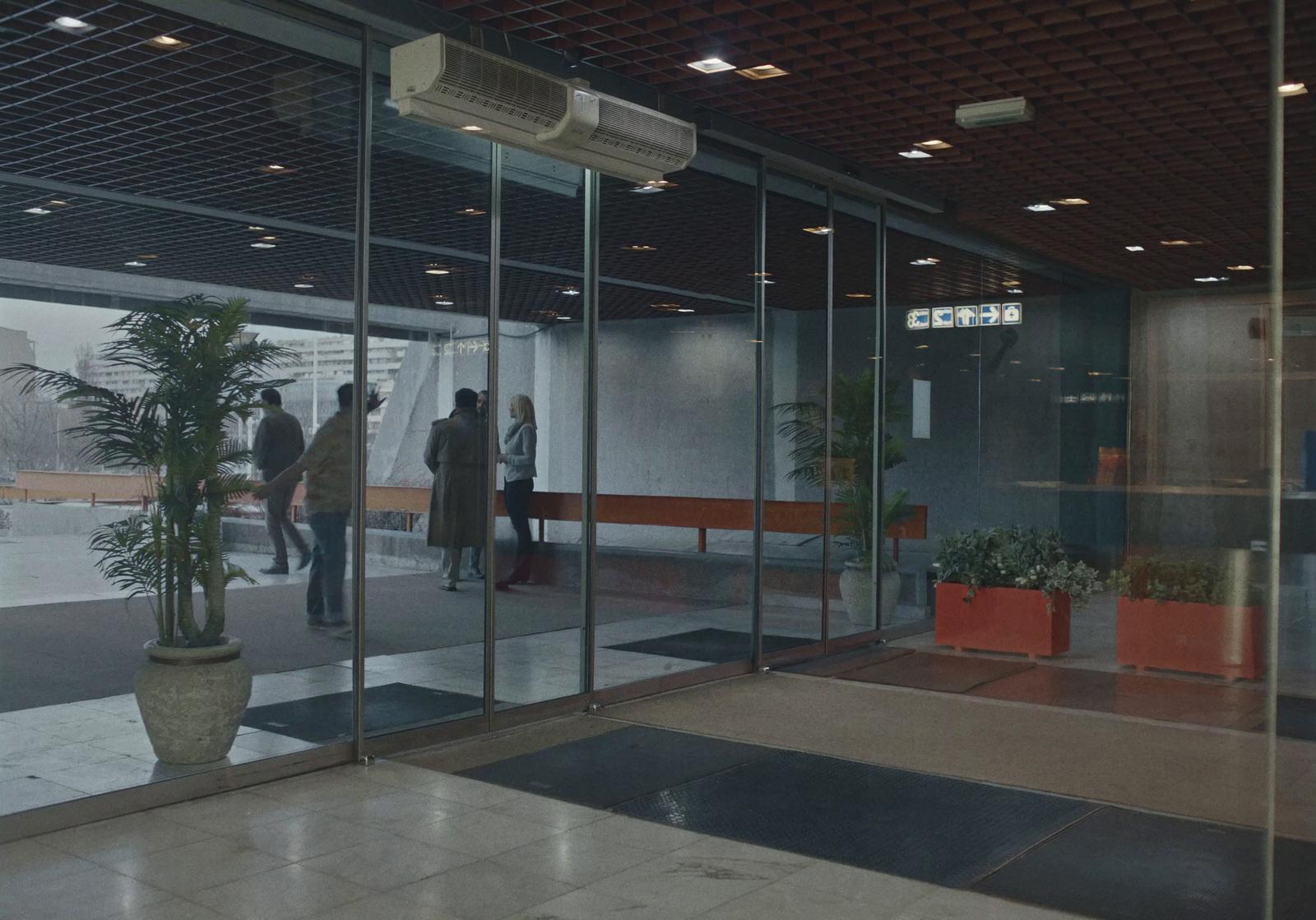 a couple of people that are standing in front of a glass door