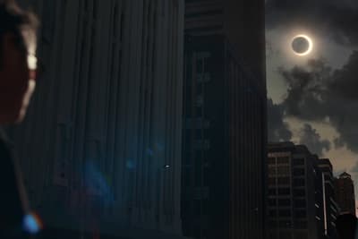 a man looking at a solar eclipse in the sky
