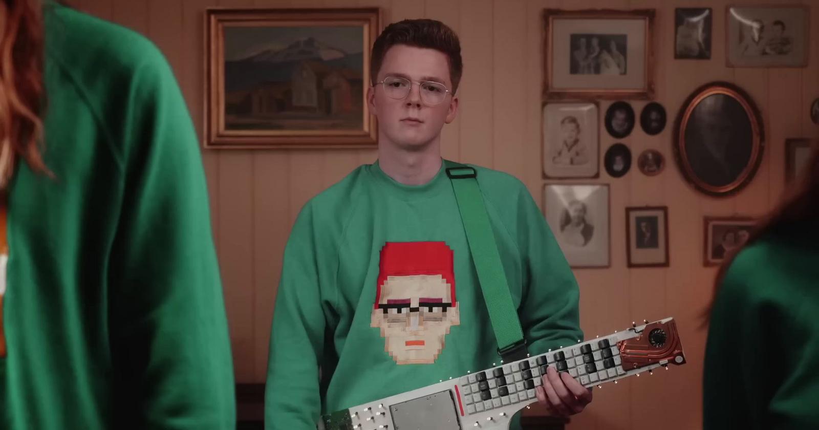 a man in a green shirt is holding a guitar