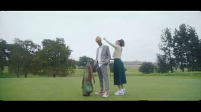 a couple of people standing on top of a lush green field