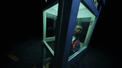 a man is looking out of a phone booth