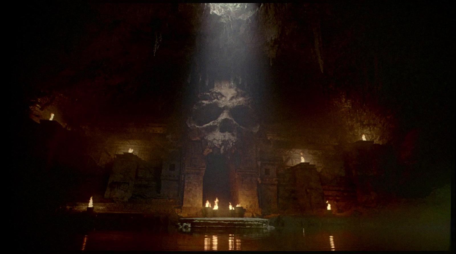 a dark cave with a light coming from the ceiling