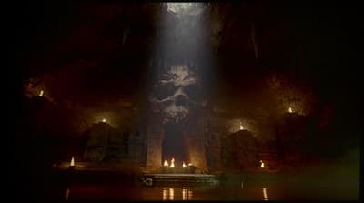 a dark cave with a light coming from the ceiling
