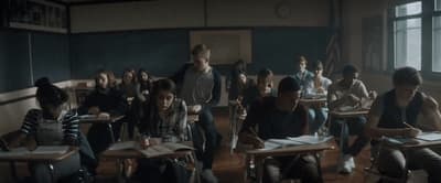 a group of people sitting at desks in a classroom