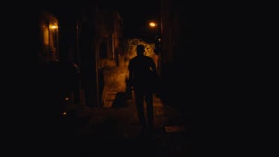 a man standing in a dark alley at night