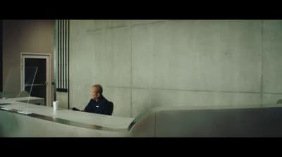 a man sitting at a counter talking on a cell phone