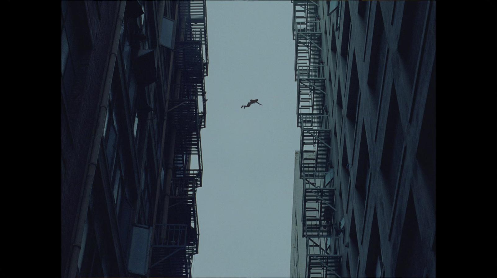 an airplane flying over a city with tall buildings