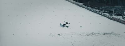 a snowboarder sliding down a snow covered slope