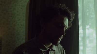 a man standing in front of a window in a room