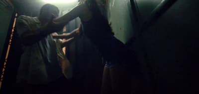 two people standing in a dark room with a light on