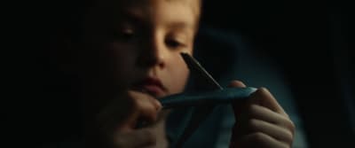 a young boy holding a pair of scissors in his hand