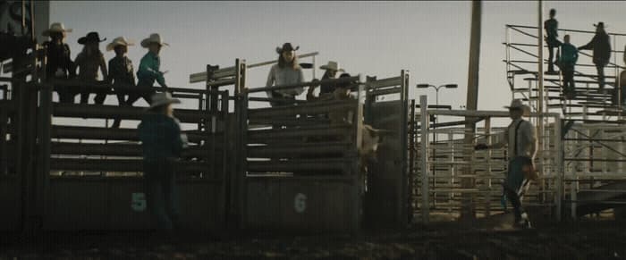 a group of men standing on top of a wooden fence