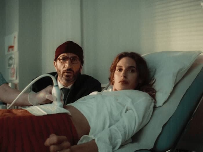 a woman laying in a hospital bed next to a man