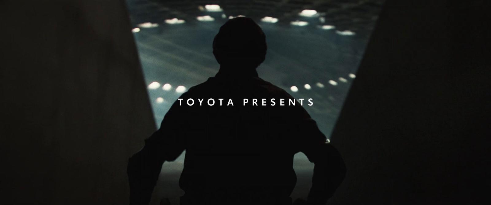 a person standing in a dark room with the words toyota presents