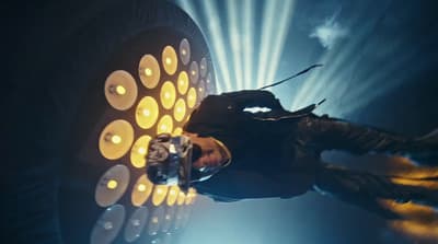 a woman standing in front of a giant speaker