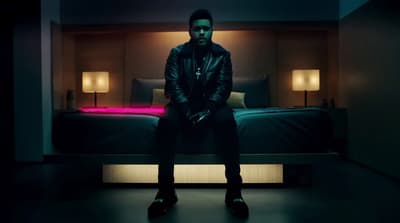 a man sitting on a bed in a dark room