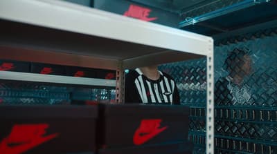 a man in a black and white striped shirt standing in a locker