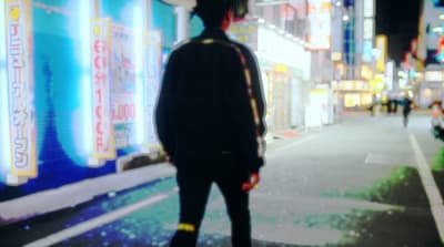 a man standing on the side of a street at night