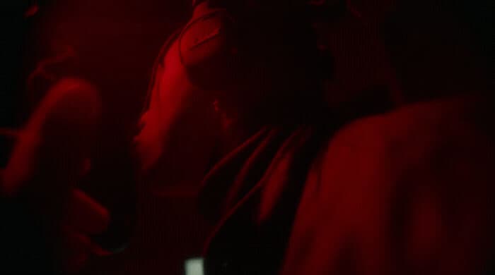 a woman in a dark room with a red light