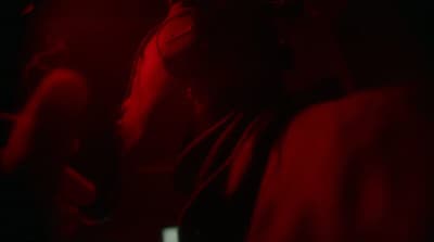 a woman in a dark room with a red light