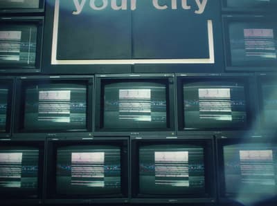 a wall of televisions with the words your city on them