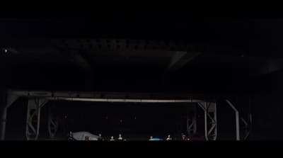a group of people standing under a bridge at night