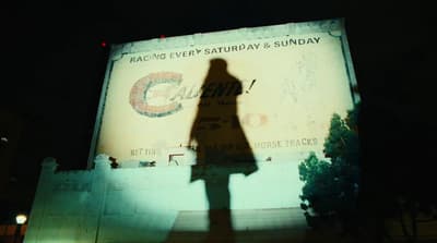 a shadow of a person standing in front of a billboard