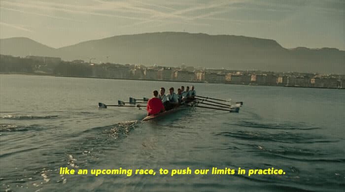 a group of people rowing a boat in the water