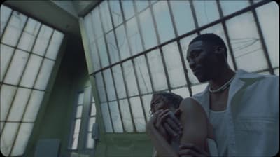a man and a woman holding hands in front of a window